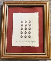 Framed block print with repeated brown lily design embossed on handmade paper, signed and numbered below.