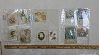 Photo showing 10 vintage Valentines cards in plastic sleeves, mostly small fold-out or decorated cards with floral and cherub themes.