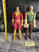 Front view of Shazam and Sandman 12-inch action figures with measuring tape showing height approx 12 inches.
