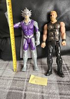 Two 12-inch Marvel action figures (Thor and Orm) placed standing next to each other showing full front view and scale with a ruler