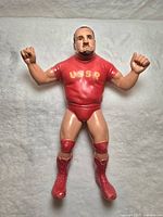 Front-facing image of 1984 LJN WWF Nikolai Volkoff action figure in red USSR outfit, showing detailed facial features and goatee.