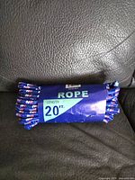Rope bundle coiled with label showing 'ROPE' and 'Length 20 FT.' on a blue and white band.