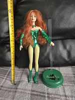 Front view of Barbie Poison Ivy doll with stand and ruler for scale