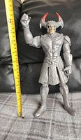 Full view of Steppenwolf figure with horned headpiece attached, showing height with tape measure.