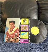 Front cover of Elvis Presley Blue Hawaii vinyl record with album jacket and record partially out.