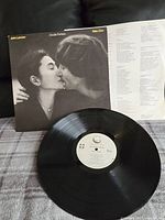 Front cover of Double Fantasy record showing John Lennon and Yoko Ono kissing in black and white.