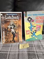 Photo of two comic books side by side, one Lady Death and one New Terrytoons featuring Heckle & Jeckle on a couch.