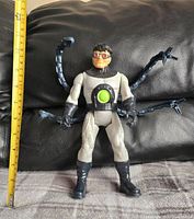 Front view of the 12-inch Doctor Octopus action figure sitting against a black background with measuring tape indicating size.