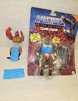 Image showing Clamp Champ action figure in blister card packaging, taped back, accompanied by loose Clawful figure and lot identifier slip