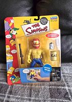 Front view of the new, sealed Ragin' Willie figure from The Simpsons with included accessories and colorful packaging.