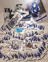 Full overview of the lot showing Toronto Maple Leafs hockey cards scattered around a collectible metal tin with a blue and white player image and the sealed silver Stanley Cup die-cut banner.