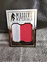 Front view of Panini Anthology Massive Materials hockey card featuring Derek Stepan with embedded white and red two-color jersey swatch and visible thick seam.