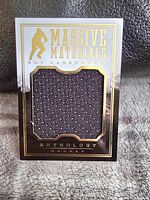 Front photo of Panini Anthology Hockey card featuring Guy Carbonneau with black jersey fabric embedded and gold foil accents.
