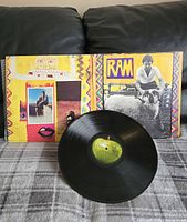 Folded open album jacket showing front and back artwork along with the vinyl record featuring the green apple label.