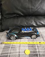 Side view of the Batman EXP Batmobile toy vehicle with measuring tape for scale showing approximately 13 inches length.