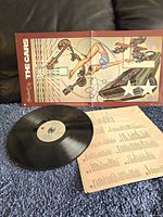 Original stylized illustrated album cover with vinyl record and lyric insert.