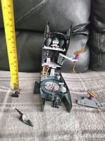 Open view of the Batcave Power Center micro playset with a tape measure showing approximately 7 inches tall. Includes multiple levels, a ladder, telescope, and various small accessories along with a Batman figure.