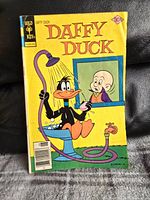 Front cover of the vintage Gold Key Daffy Duck comic book showing Daffy Duck in a bathtub with a showerhead and a colorful title.