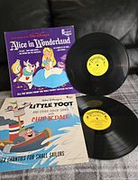 Photo showing two vinyl records and their colorful illustrated sleeves with Disney characters from Alice in Wonderland and Little Toot with Chip 'N' Dale.