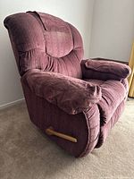 Side angle view of large burgundy velvet La-Z-Boy recliner showing plush padded armrest and wooden recline lever