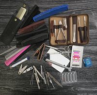 Overview of all personal care items laid out on dark wood surface showing grooming kit, combs, nail clippers, tweezers, hair clips, nail files, mirror, and floss.