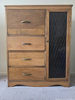Closed front view showing four wooden drawers on the left and a glass-paneled door on the right with diamond pattern, metal drawer pulls and knob.