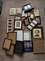 Top view of a collection of about twenty-five assorted picture frames in mixed materials and sizes.