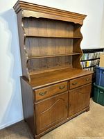 Front angled view of the solid rock maple hutch showing upper shelving with plate grooves and lower drawers and cupboard doors.