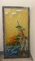 Full front view of the tall rectangular painted glass art panel showing the sunset, eagle, tree, waves, and mountains.
