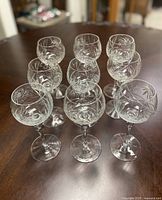 Front view of all 9 crystal stemware glasses showing cut glass design and rounded bowls.