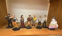Full set of 8 Firefly character action figures displayed on a wooden shelf, each on a black hexagonal base stand.