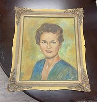 Front view of the framed oil painting showing the portrait of a woman with detailed colors and textured brushstrokes, signed by the artist.