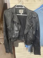 Black faux leather cropped jacket by Esley with zipper, pockets, size L tag shown