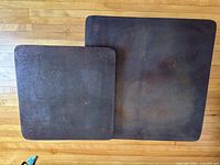 Top-down view of tabletops showing dark brown metal surfaces with visible texture and surface wear.