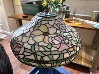 Side view of Tiffany style stained glass ceiling light showing floral design in pink, white and yellow flowers with green leaves and border.