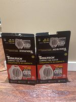 Two Tooltech compact fan heaters in their retail boxes, showing product image and branding on front.