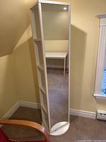 Front view showing full-length mirror attached to one side and the round base.