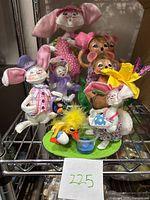 Seven Annalee felt Easter dolls including rabbits, a duck, and mice displayed on metal shelving with a handwritten sign 225
