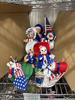 Seven patriotic themed Annalee felt dolls with American flags and drums displayed in a box