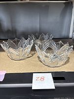 Three clear crystal bowls grouped on a surface, showing their size, form, and pattern.