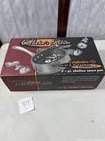 Box of Calphalon Collector's Edition 2.5 quart shallow sauce pan showing branding and key features.