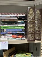 Books stacked with visible titles including The Gourmet Cookbook Volume 1 and 2, A Movable Feast, and others.