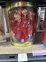 Front view of the Barbie doll in original packaging showcasing the bright red glittery dress and holiday-themed accessories.