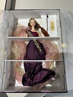 Heartstring Angel Barbie doll dressed in purple gown with gold embroidery, holding a violin and bow, inside original box with fabric wings.