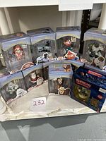 Collection of 10 boxed The Island of Misfit Toys ornaments displayed on shelf with a lot number card '232'. Multiple characters visible inside clear display packaging.