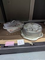 View of the lot showing stack of 6 bowls with bird and floral design, white handled serving tray, and covered tureen with floral patterns.
