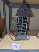 Front view of the mid century chunk glass lamp, showing the metal frame with colorful glass pieces and tiered top.