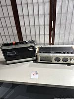 Both items side by side on white table showing the Realistic CTR-9 cassette recorder on the left and the Panasonic RC-7055 radio clock on the right
