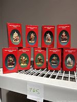 All 9 porcelain Santa figurines in original red boxes displayed in two rows, showing product design and labeling.