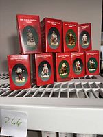 Nine boxed hand painted porcelain Santa figurines from the 'Santas of the Nations' collection, stacked and displayed.